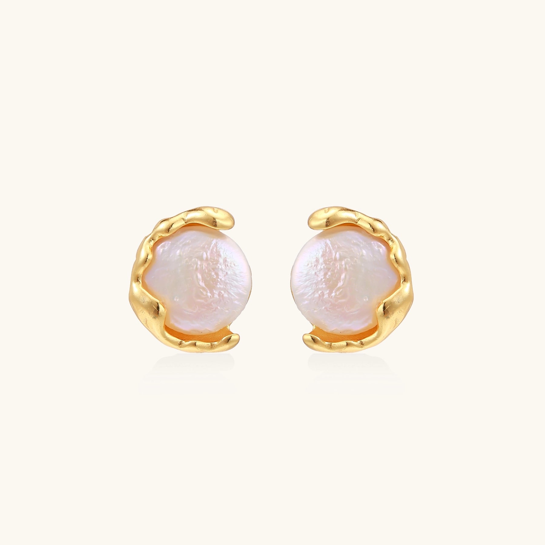 Gold-plated sterling silver stud earrings with organic claw settings cradling lustrous freshwater pearls on white background.