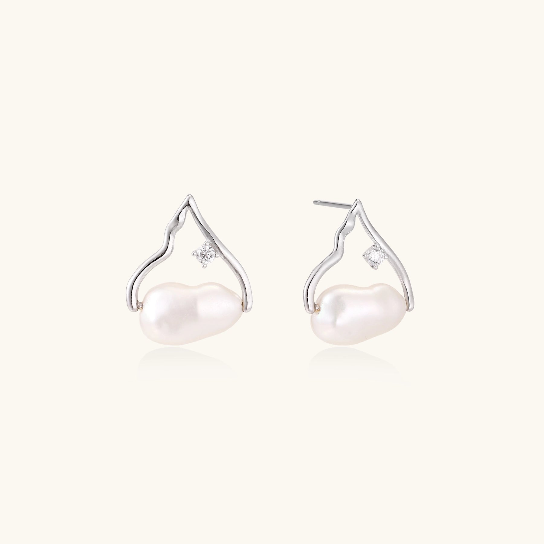 Sterling silver teardrop-shaped stud earrings with white freshwater pearls nestled in elegant flame-like frames