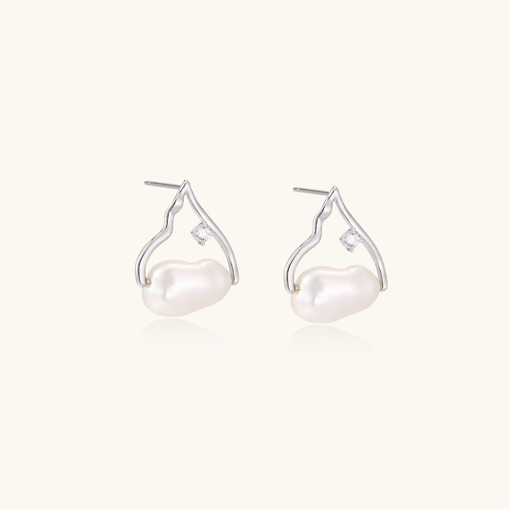 Sterling silver teardrop-shaped stud earrings with white freshwater pearls nestled in elegant flame-like frames