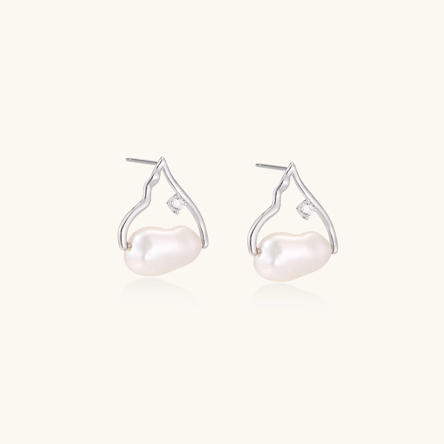Sterling silver teardrop-shaped stud earrings with white freshwater pearls nestled in elegant flame-like frames