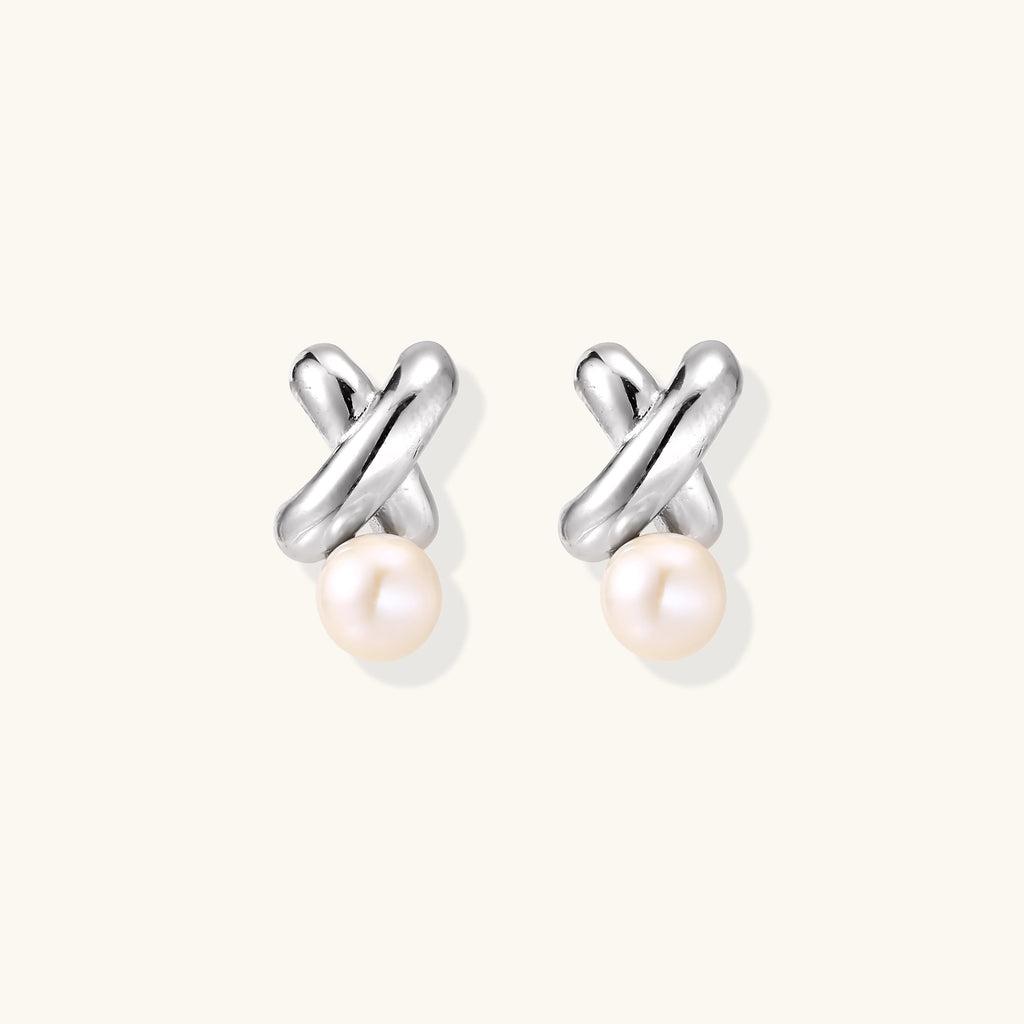 Sterling silver twisted stud earrings with round freshwater pearls on cream background, showing polished finish