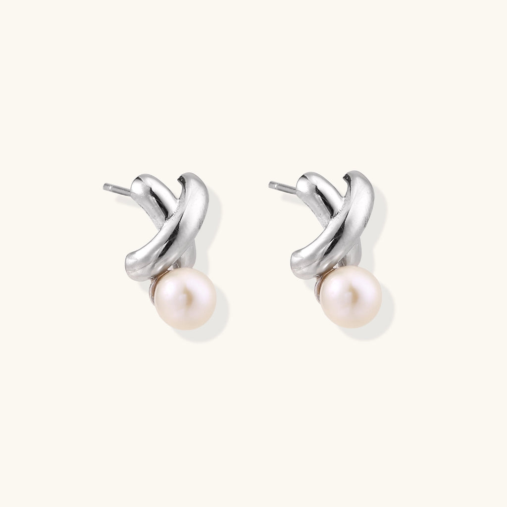 Sterling silver twisted stud earrings with round freshwater pearls on cream background, showing polished finish