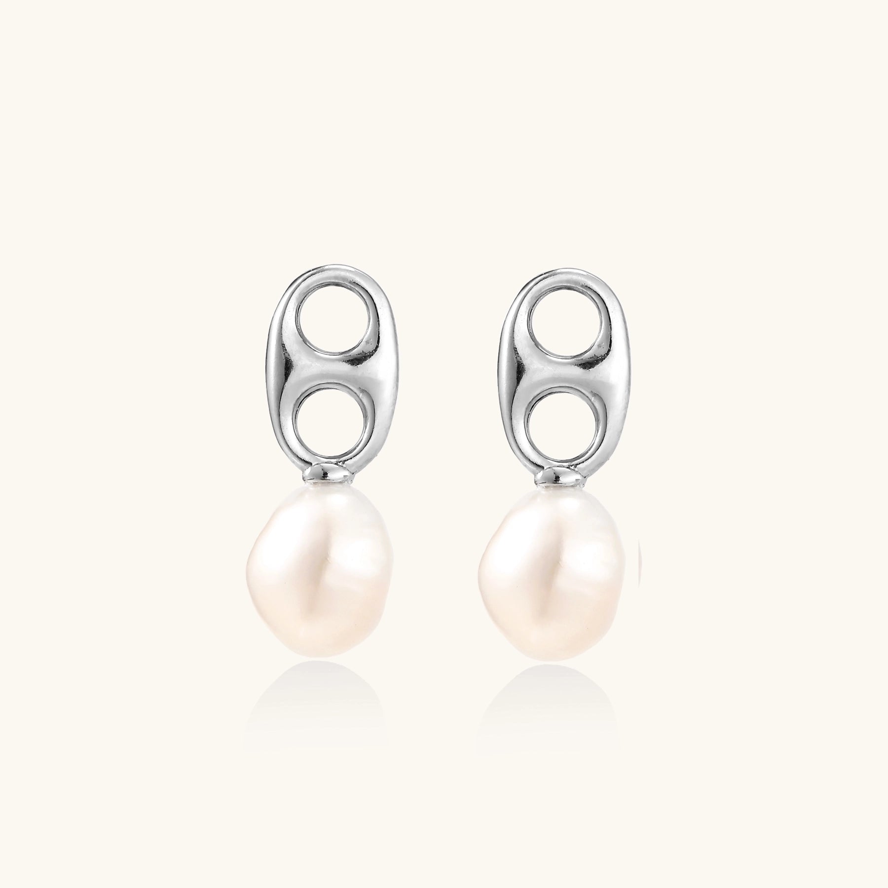 Sterling silver oval stud earrings with dual circular cutouts and suspended freshwater pearls on white background.