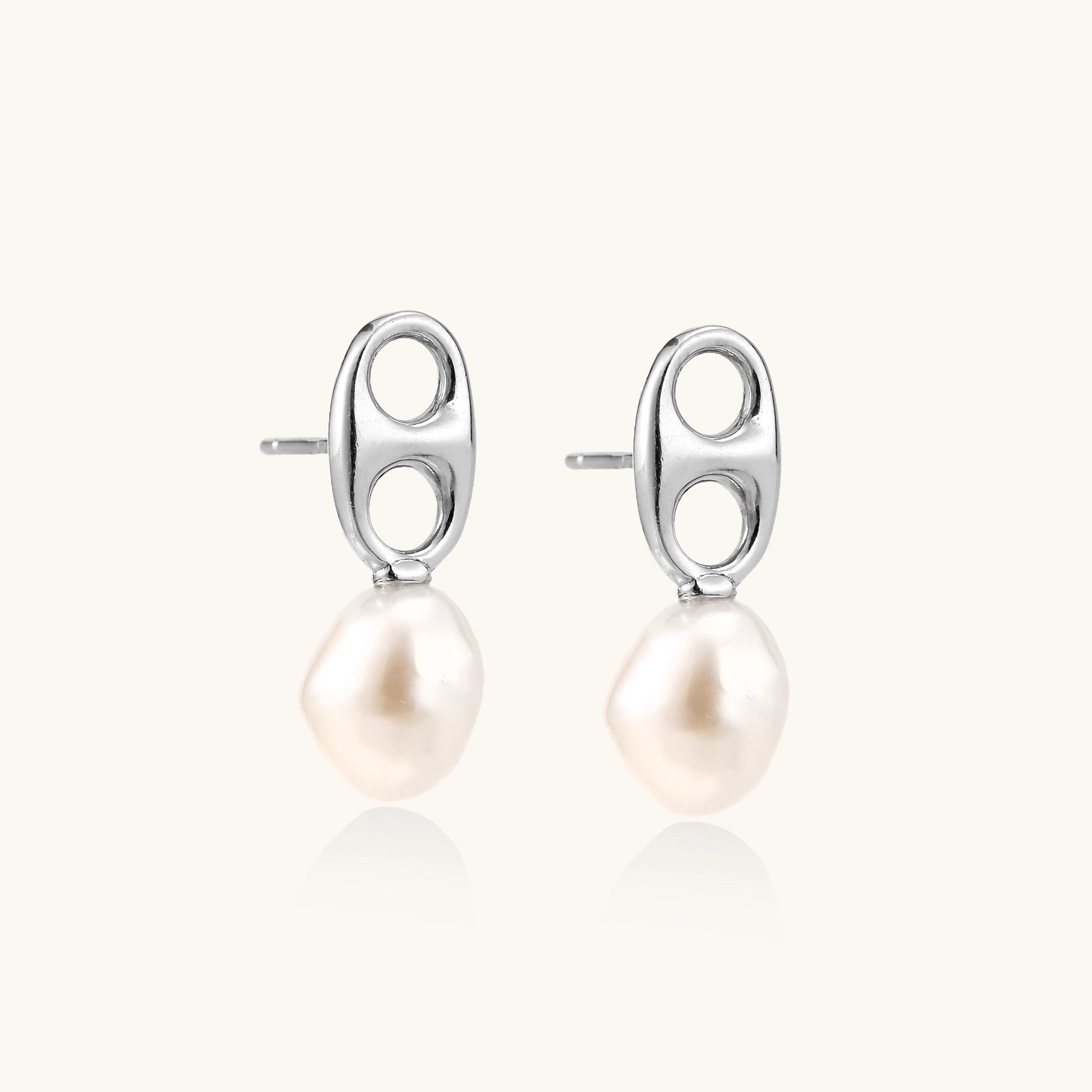 Sterling silver oval stud earrings with dual circular cutouts and suspended freshwater pearls on white background.