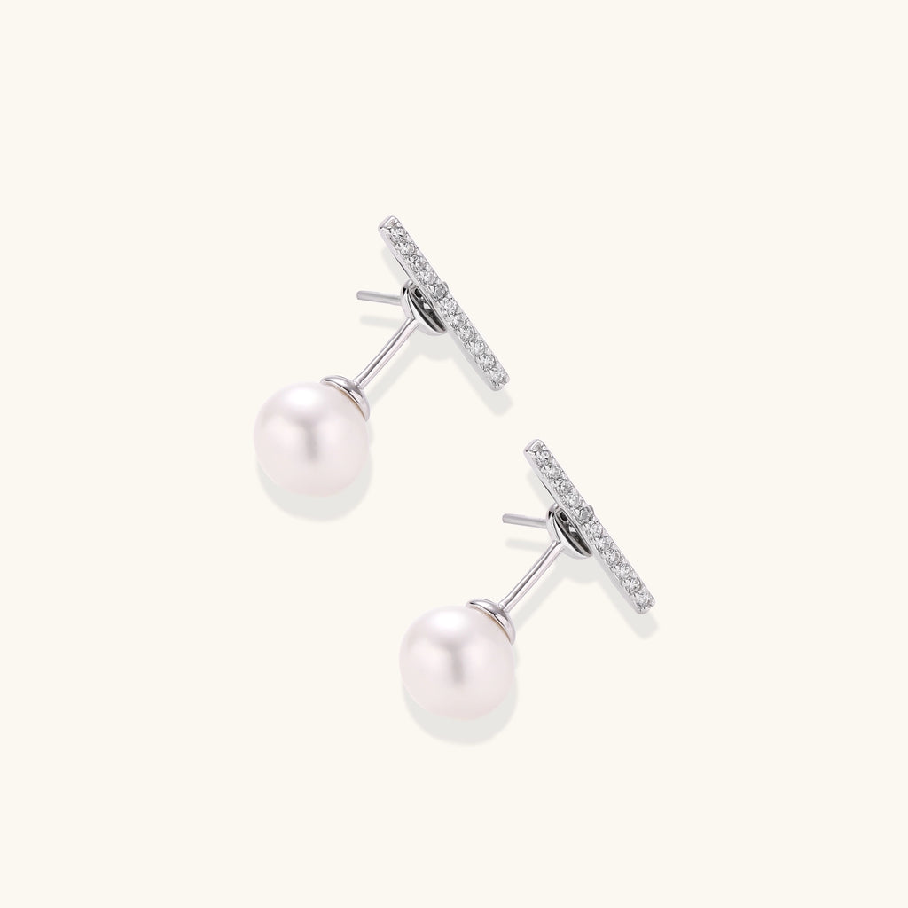 Sterling silver bar stud earrings with freshwater pearl drops on white background, minimalist jewelry design