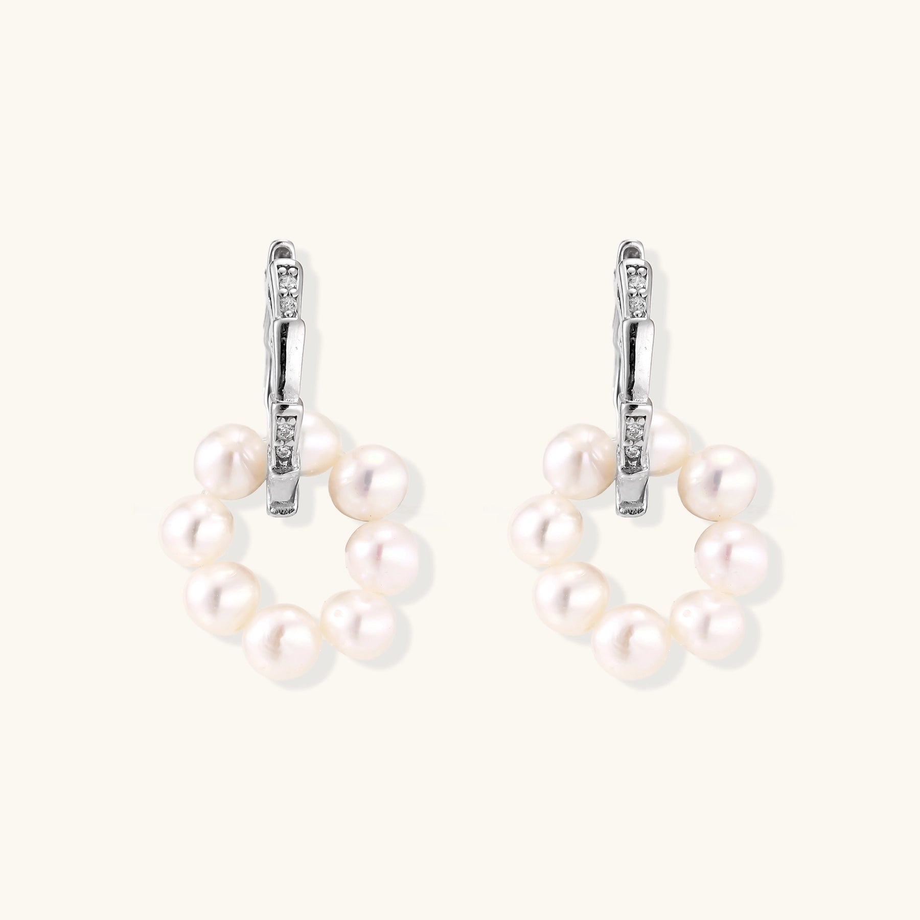 Sterling silver huggie hoop earrings with clustered white freshwater pearls and crystal accents on white background.