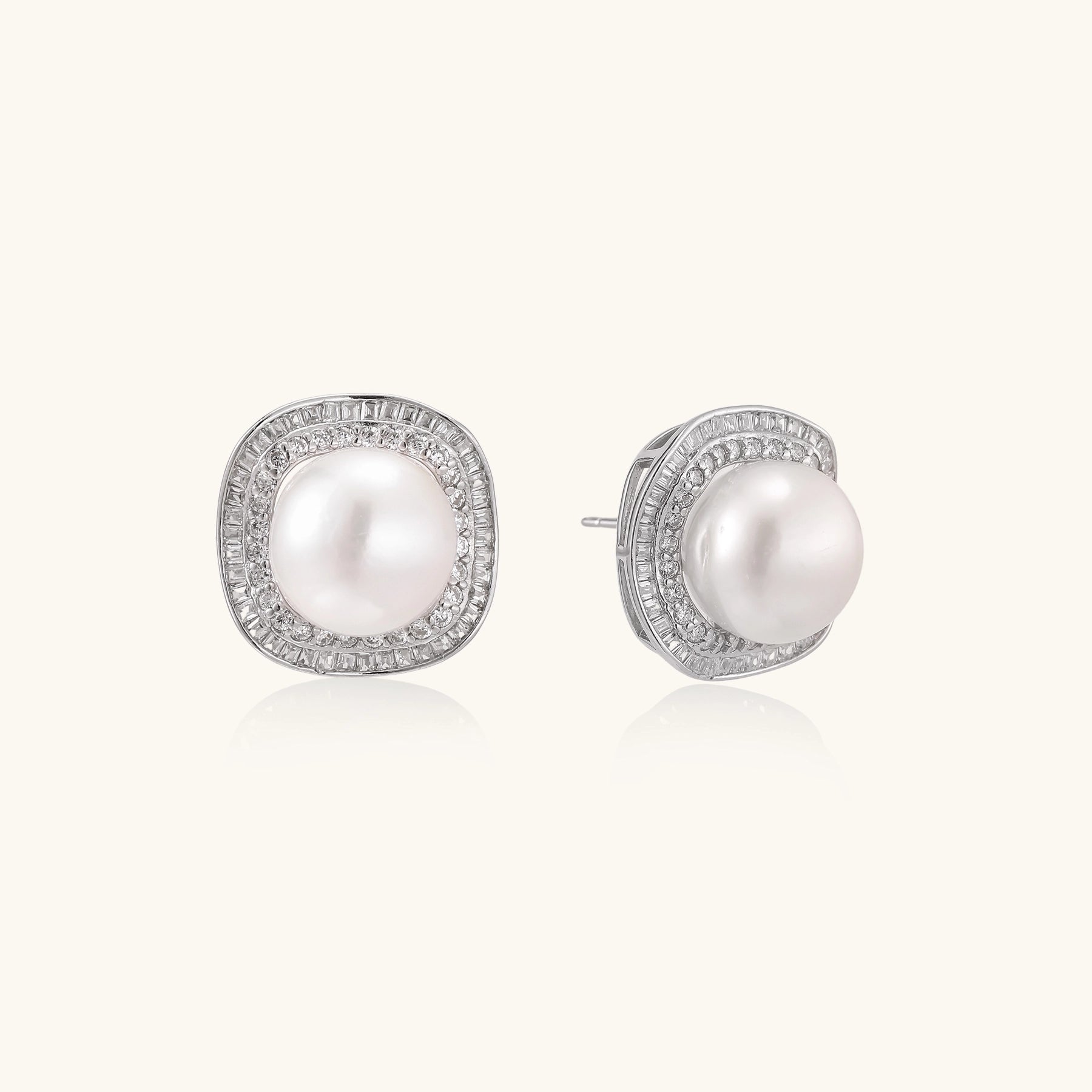 Sterling silver stud earrings with round freshwater pearls surrounded by sparkling crystal halos on white background.