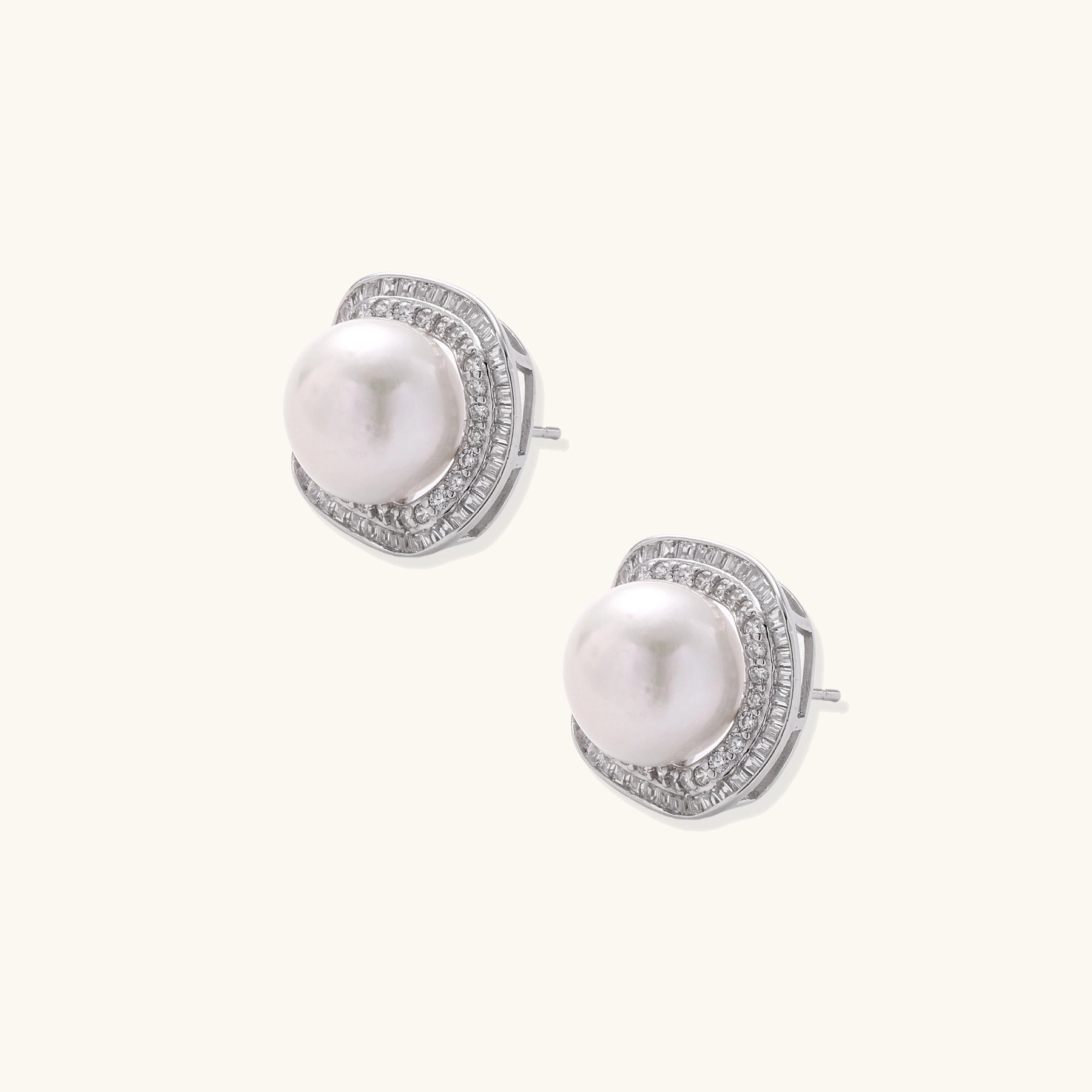 Sterling silver stud earrings with round freshwater pearls surrounded by sparkling crystal halos on white background.