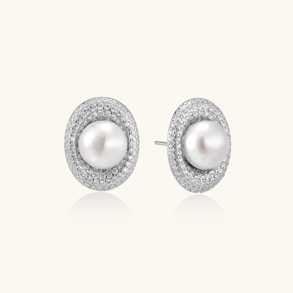 Sterling silver stud earrings with freshwater pearls surrounded by sparkling pavé crystals on white background.