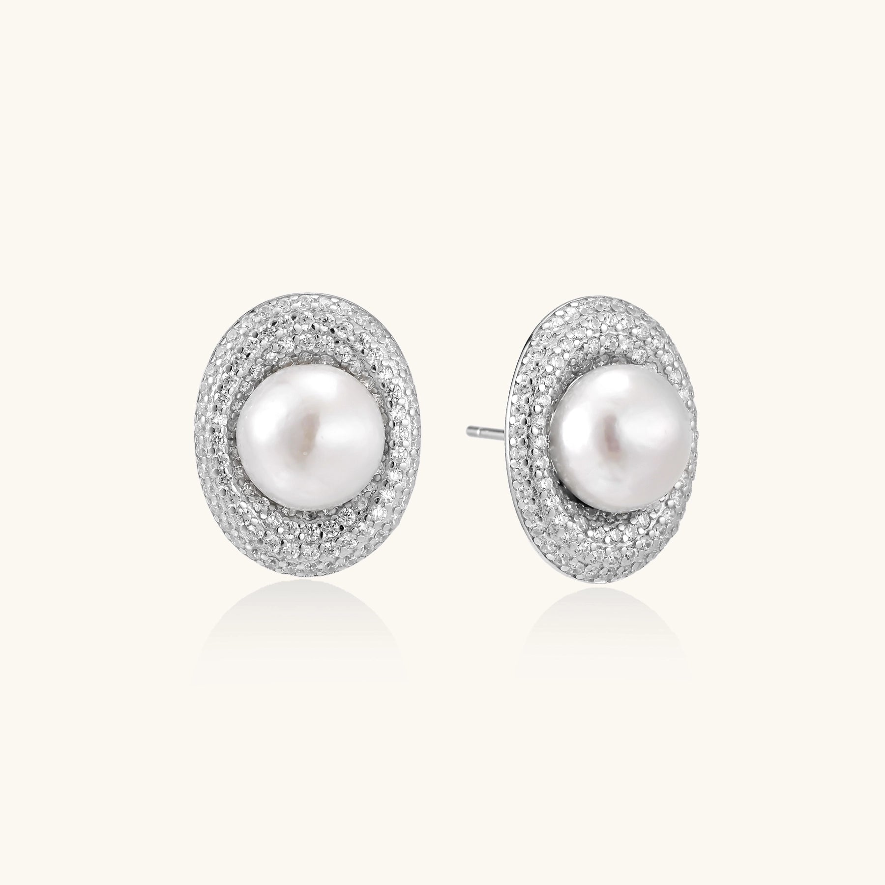 Sterling silver stud earrings with freshwater pearls surrounded by sparkling pavé crystals on white background.