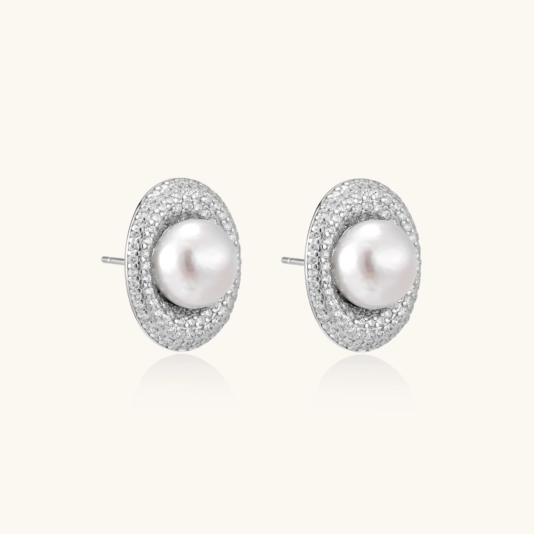 Sterling silver stud earrings with freshwater pearls surrounded by sparkling pavé crystals on white background.