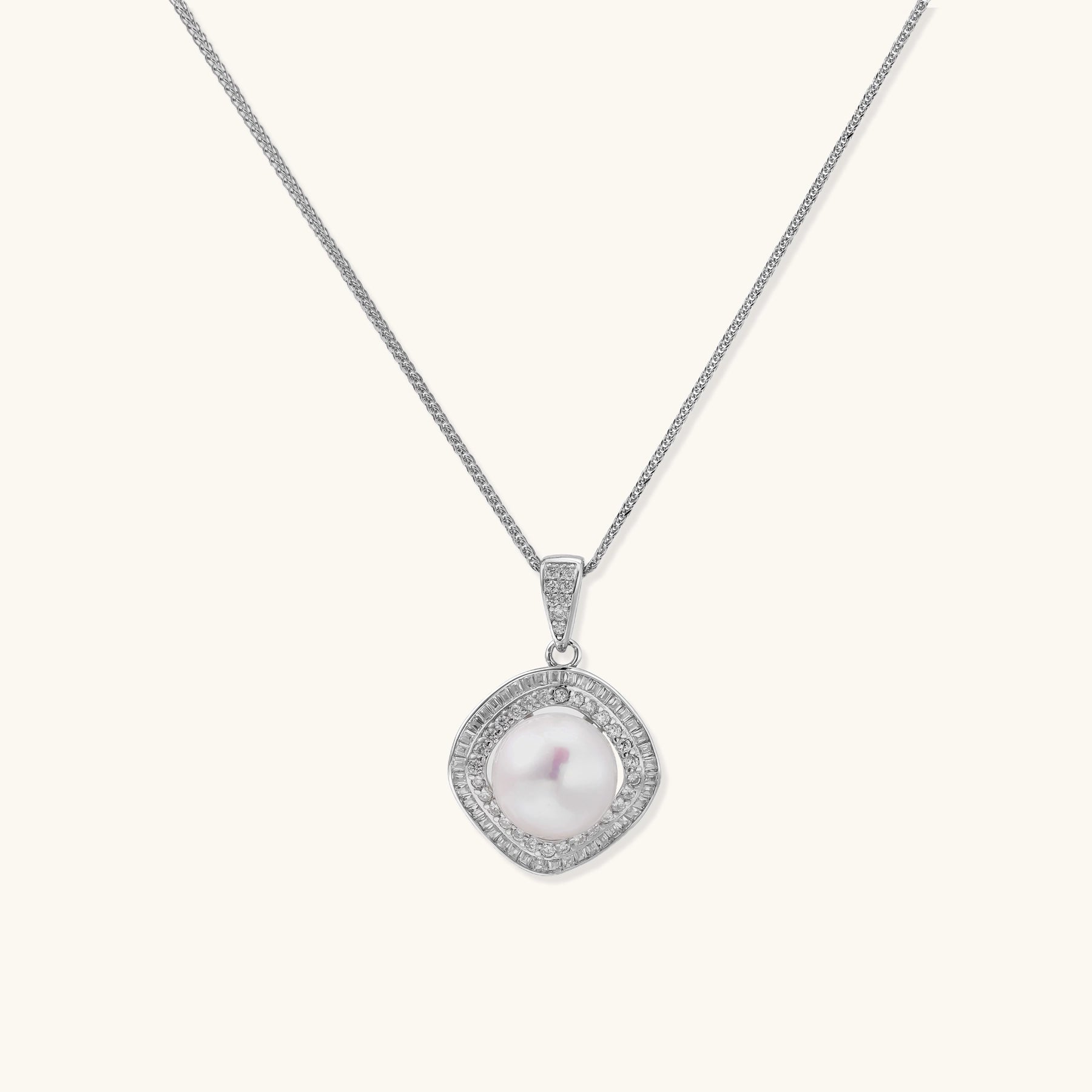 Sterling silver necklace with geometric halo setting surrounding a 10mm freshwater pearl on white background.