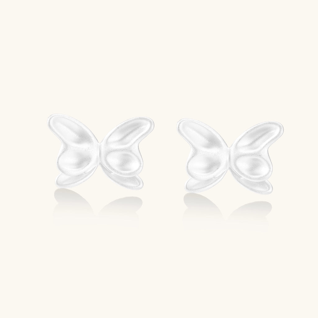 Delicate sterling silver butterfly stud earrings with intricate wing details on a neutral background.