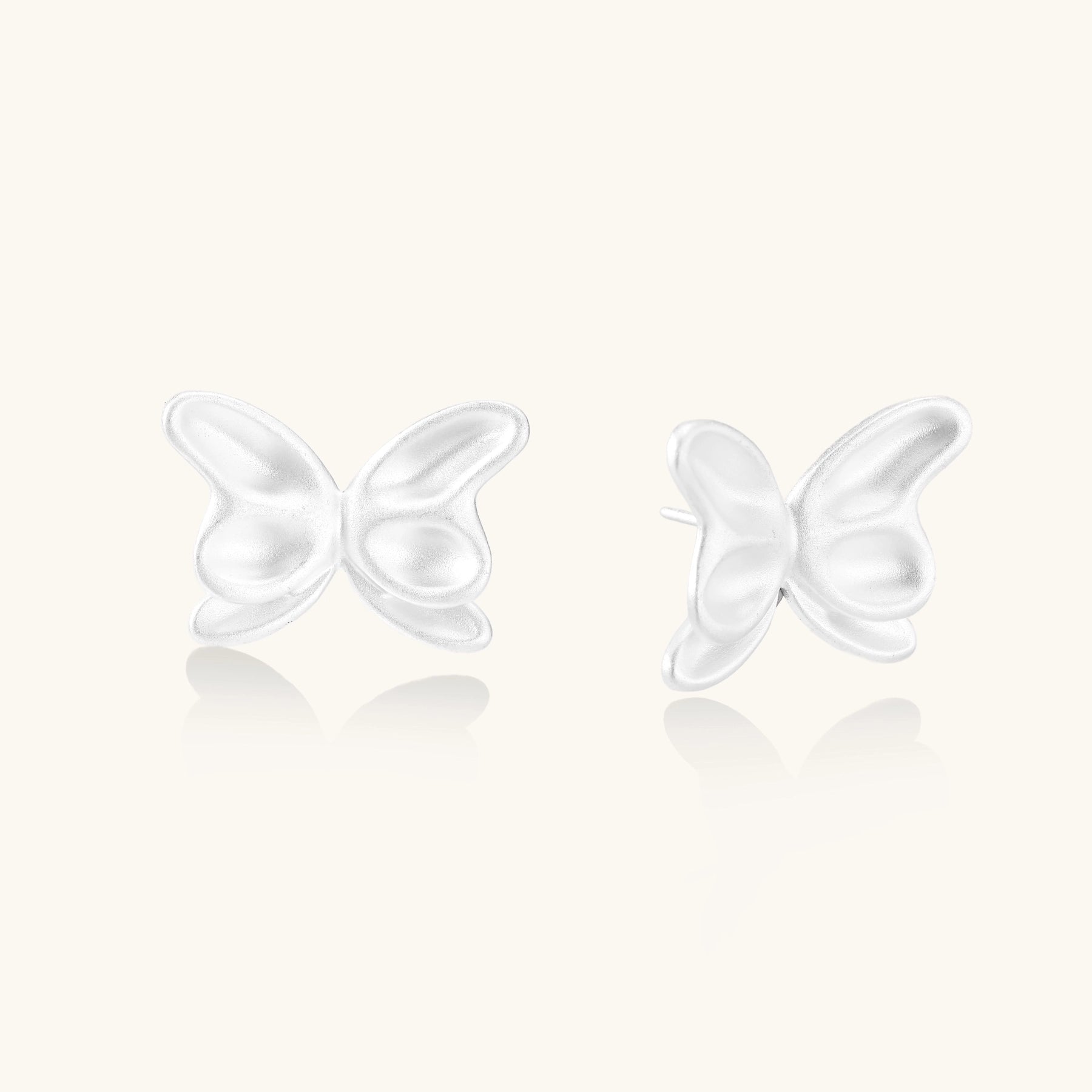 Delicate sterling silver butterfly stud earrings with intricate wing details on a neutral background.
