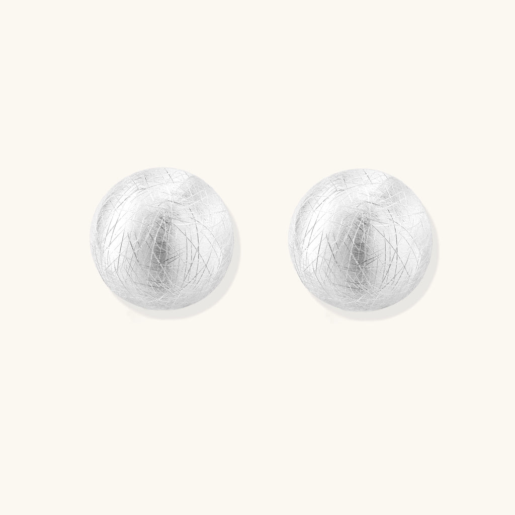 Brushed sterling silver dome-shaped stud earrings with textured surface and secure lever-back closure on white background.