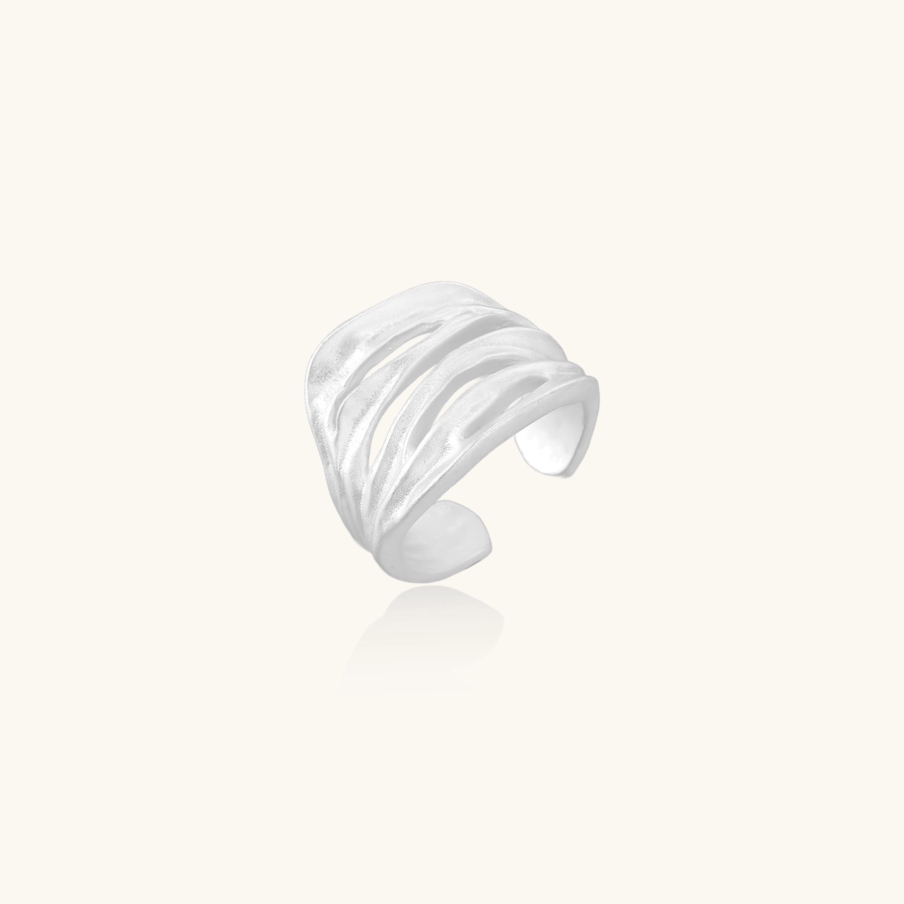Wide sterling silver ring with flowing wave patterns and adjustable cuff design on white background.