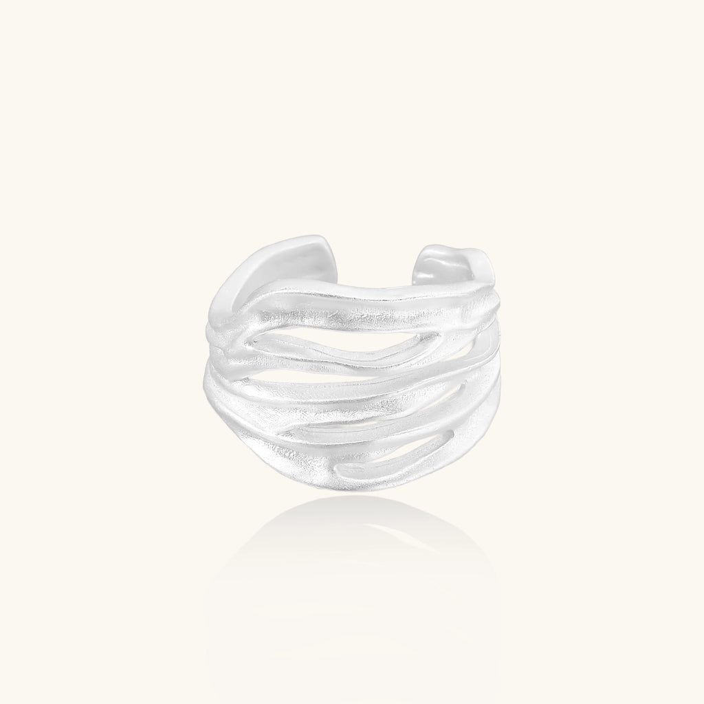 Wide sterling silver ring with flowing wave patterns and adjustable cuff design on white background.