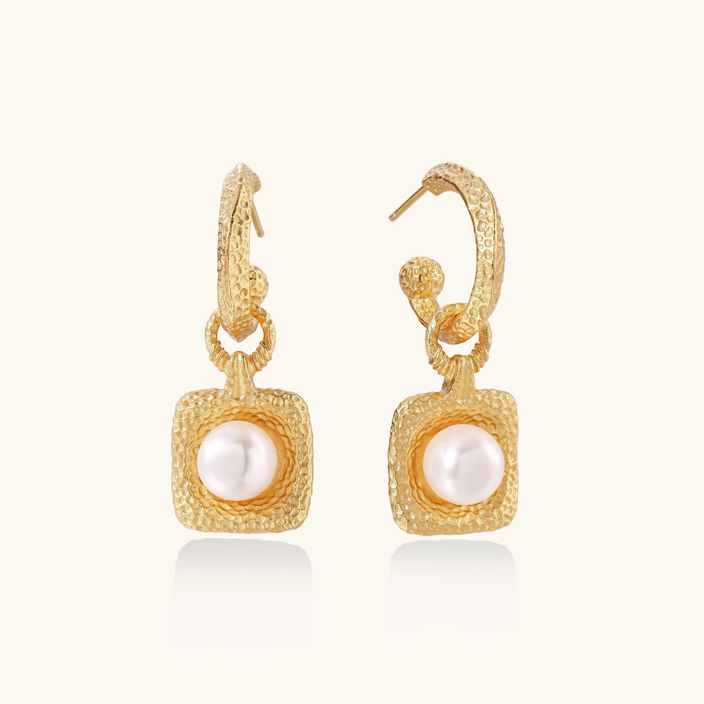 Gold-plated textured hoop earrings with square pendants containing freshwater pearls on white background