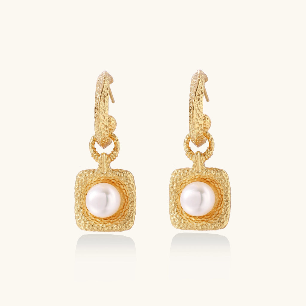 Gold-plated textured hoop earrings with square pendants containing freshwater pearls on white background