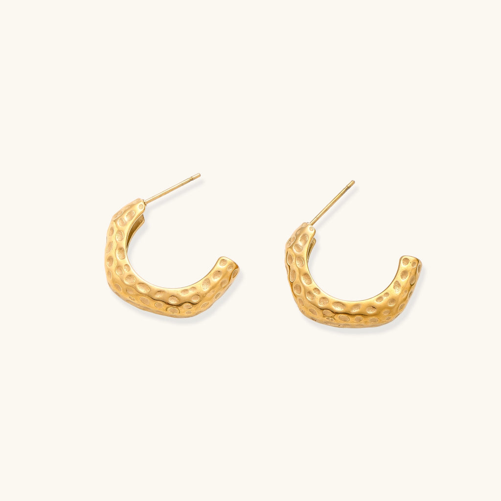 Textured gold-plated hoop earrings with dimpled surface pattern and post backs on neutral background.