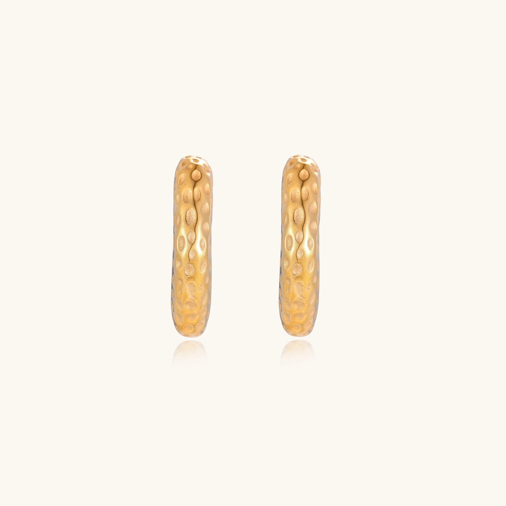 Textured gold-plated hoop earrings with dimpled surface pattern and post backs on neutral background.