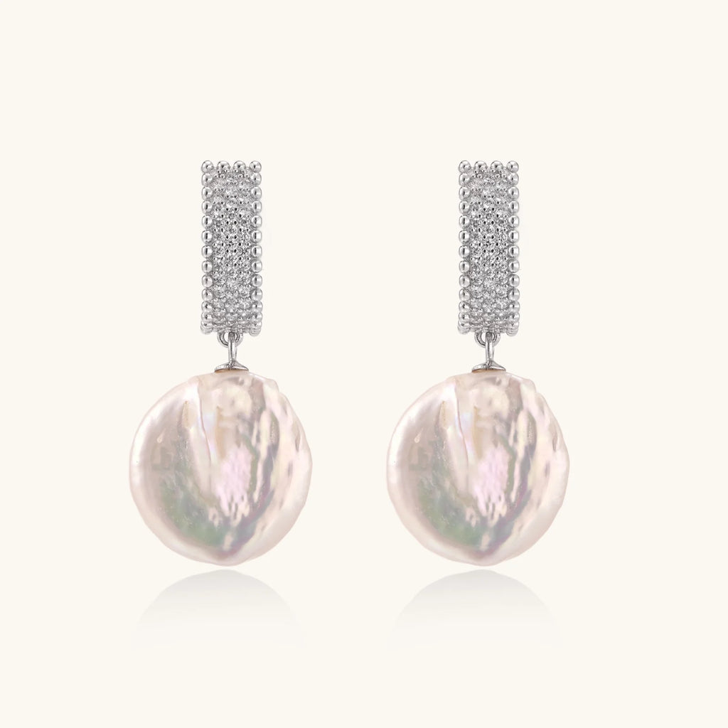 Rhodium-plated silver curved stud with pave stones and baroque pearl drop on white background